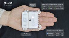 A white square technology device held in the palm of a hand 
