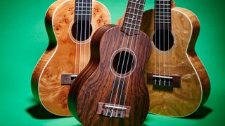 Three ukuleles on green background