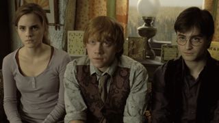 Hermione, Ron, and Harry sitting listening to Rufus Scrimgeour in Deathly Hallows: Part 1.