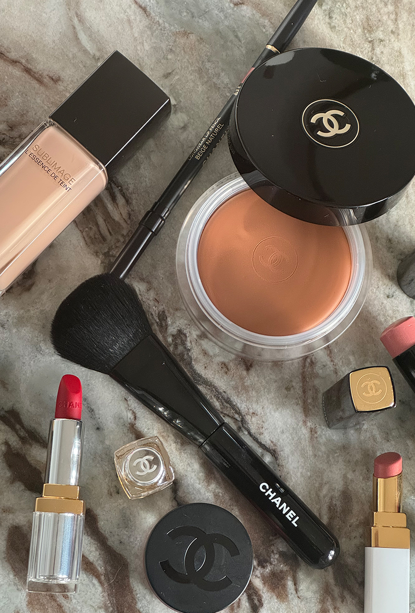 Chanel makeup products scattered on a marble table