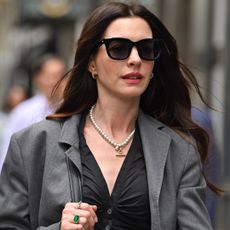 Anne Hathaway styled a gray suit set and a Coach bag on the Devil Wears Prada 2 set