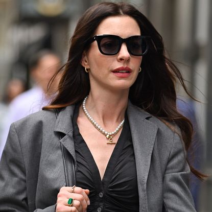 Anne Hathaway styled a gray suit set and a Coach bag on the Devil Wears Prada 2 set