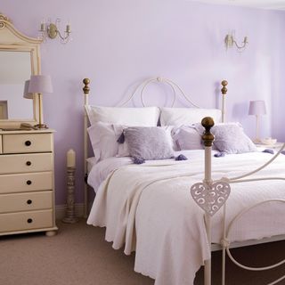 guest room with purple wall and candle inside bed