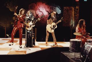 Jim Lea rocking away with Slade in the 1970s, wearing his famous red suit.