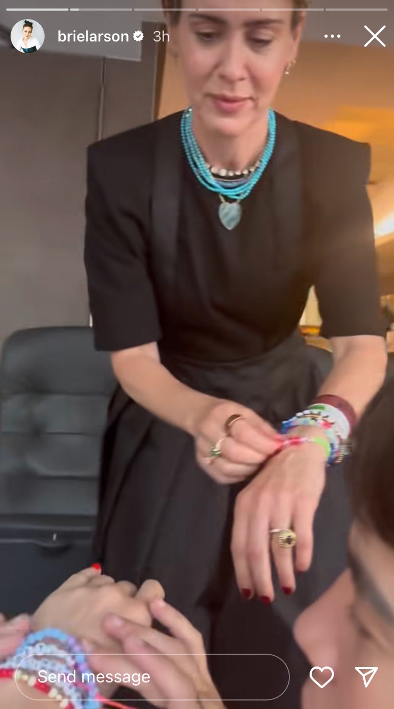 Sarah Paulson trading a friendship bracelet with Brie Larson at the Eras Tour.