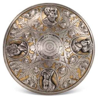 Here, the bottom of a silver bowl that has bosses (protrusions) that depict ancient Greek deities. Zeus, king of the gods, can be seen at top of this image.