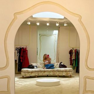 Woman sitting on floral couch taking a mirror selfie at Happy Isles in Los Angeles.
