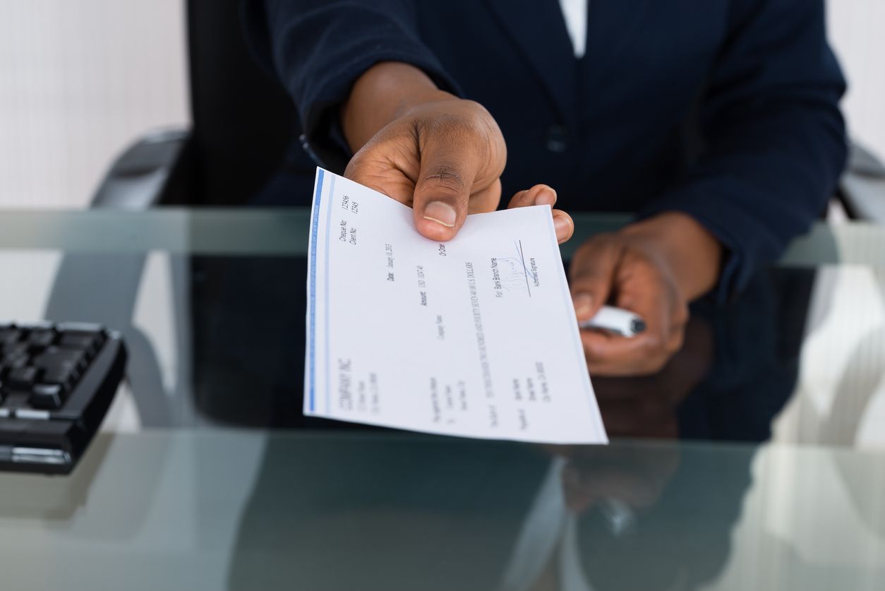 Person handing over a check.