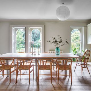 Dining room in period house with long wooden table and wooden chairs