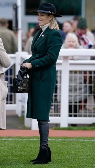 Zara Tindall stands talking to others at Cheltenham Racecourse on December 16, 2023