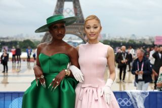 (L-R) Cynthia Erivo in a green dress and hat and Ariana Grande in a light pink dress attend the red carpet ahead of the opening ceremony of the Olympic Games Paris 2024 on July 26, 2024 in Paris, France.