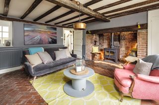 cottage style living room with beams and inglenook fireplace