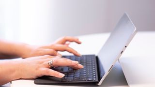 Closeup of woman working and typing on a tablet PC.