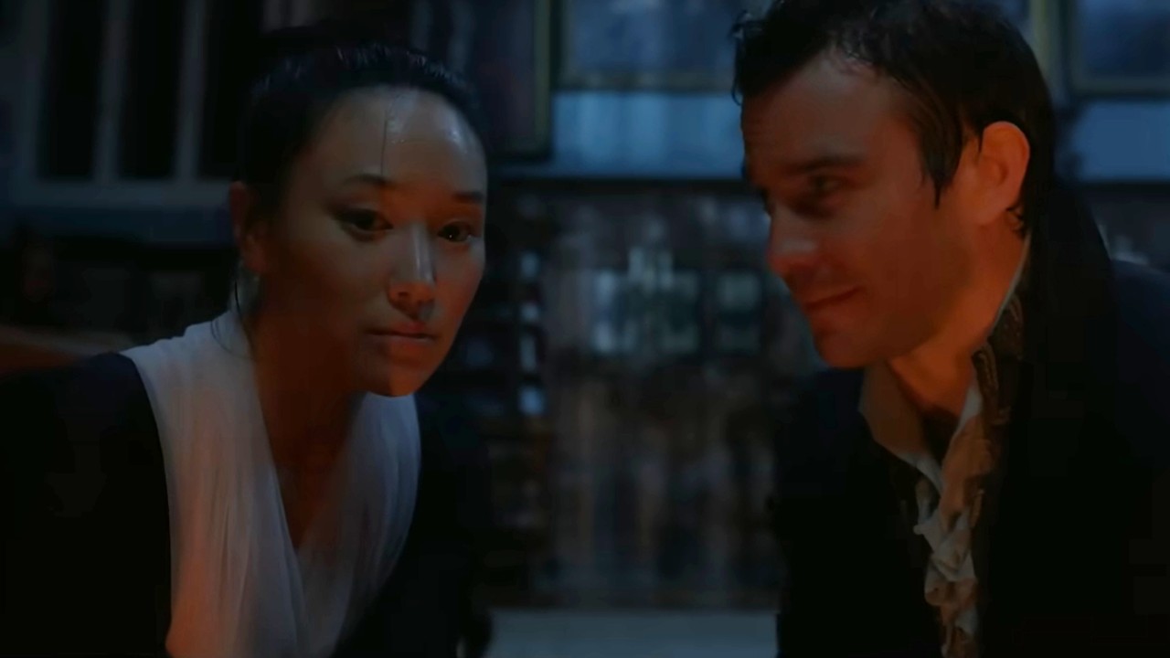 Luke Thompson looks at Yerin Ha in Bridgerton.