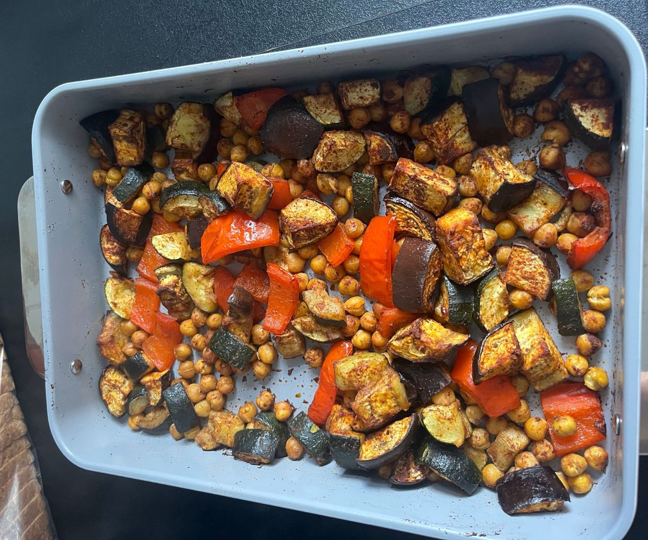 A rectangular baking tray with roasted vegetables inside