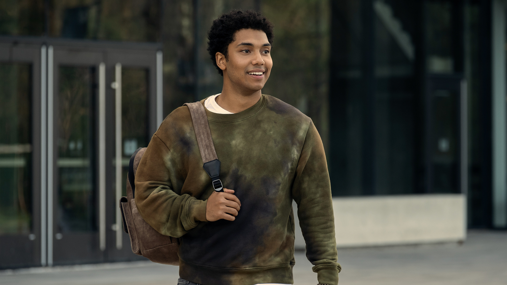 Andre Anderson smiling and carrying his backpack on his right shoulder in Gen V season 1