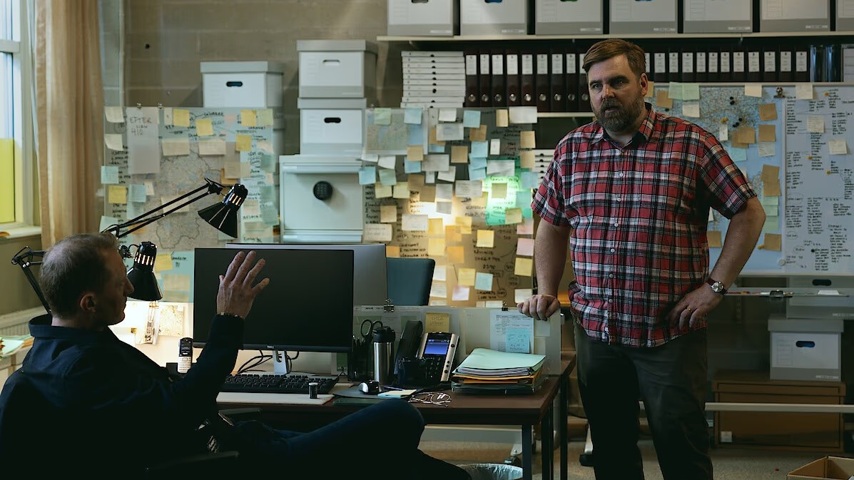 John og Per sidder på et kontor og diskuterer noget i Netflix-serien The Breakthrough.