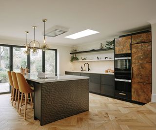 A black and white kitchen with metallic cabinet fronts