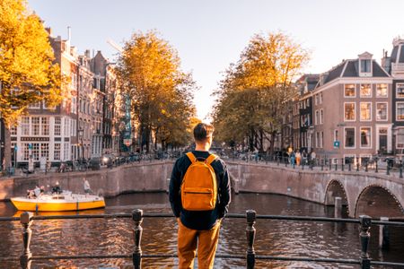 A young man looking over the canal of Amsterdam