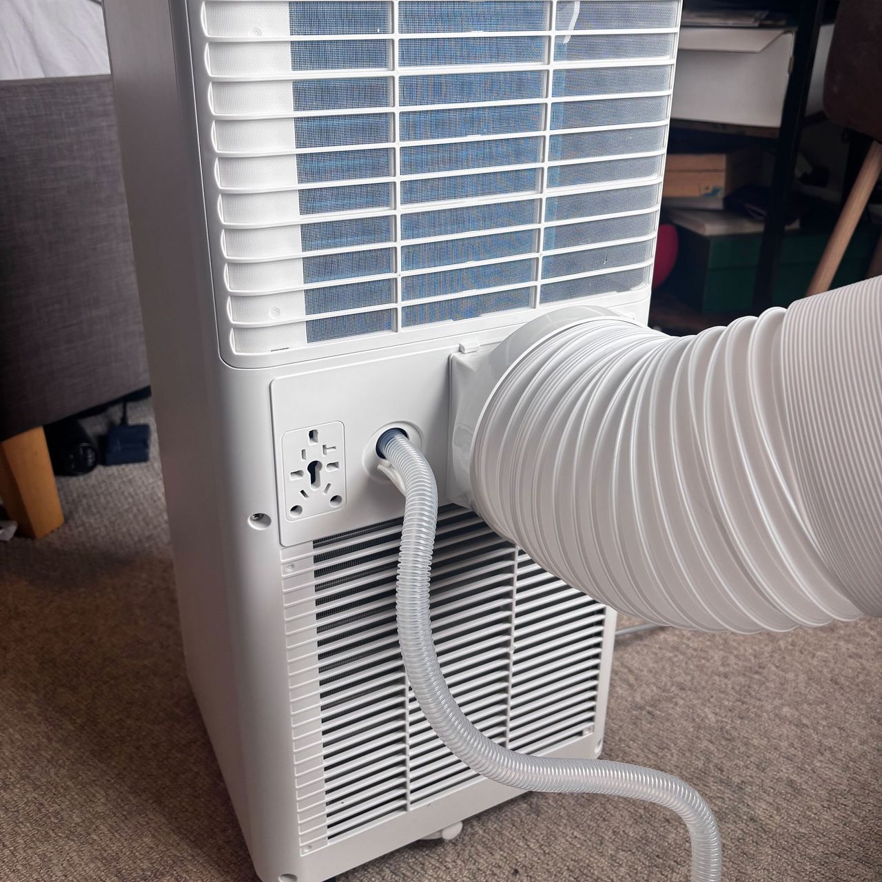 back of air conditioning unit showing exhaust pipe and drainage pipe