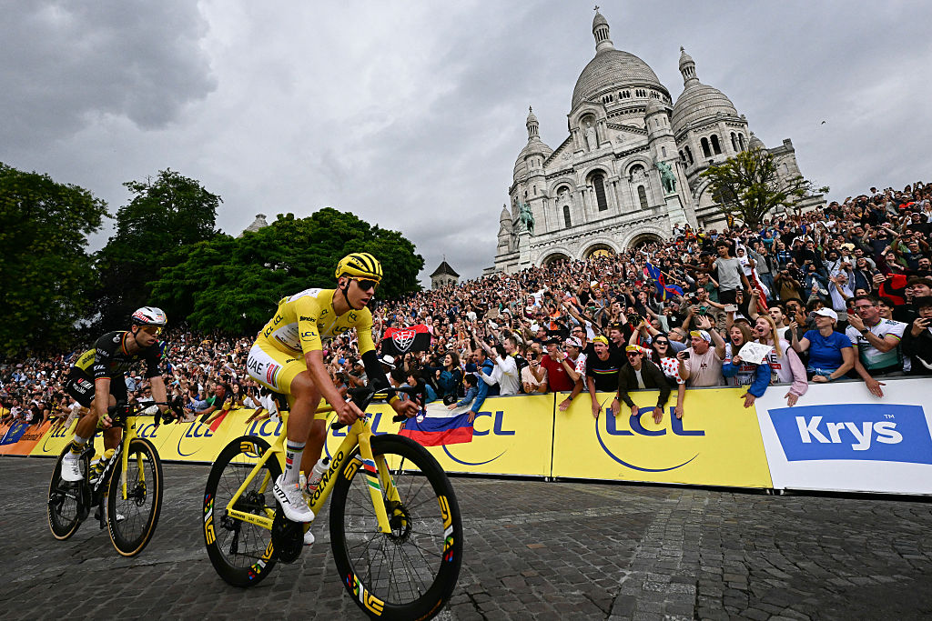 UAE Team Emirates - XRG team's Slovenian rider Tadej Pogacar wearing the overall leader's yellow jersey and Team Visma - Lease a bike team's Belgian rider Wout van Aert cycles past the Sacre-Coeur Basilica on the Butte de Montmartre during the 21st and final stage of the 112th edition of the Tour de France cycling race, 132.3 km between Mantes-la-Ville and Paris' Champs-Elysees Avenue, on July 27, 2025. (Photo by Loic VENANCE / AFP)