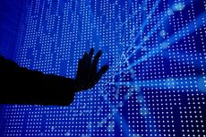 Hand touching mass of blue dots