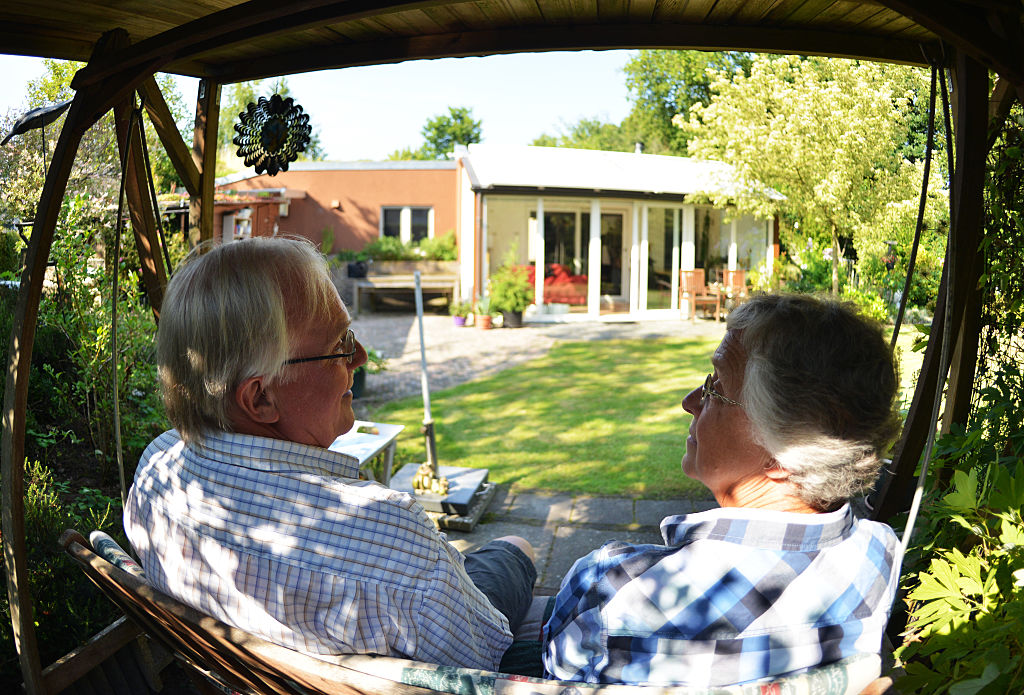 A couple looking in their garden looking at their home considering equity release
