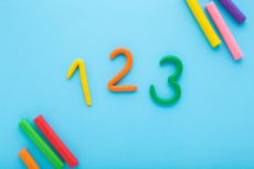 Colorful 123 numbers created from modeling clay on light blue table background. 