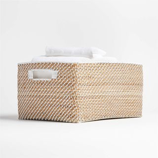 A rattan storage basket with white detailing
