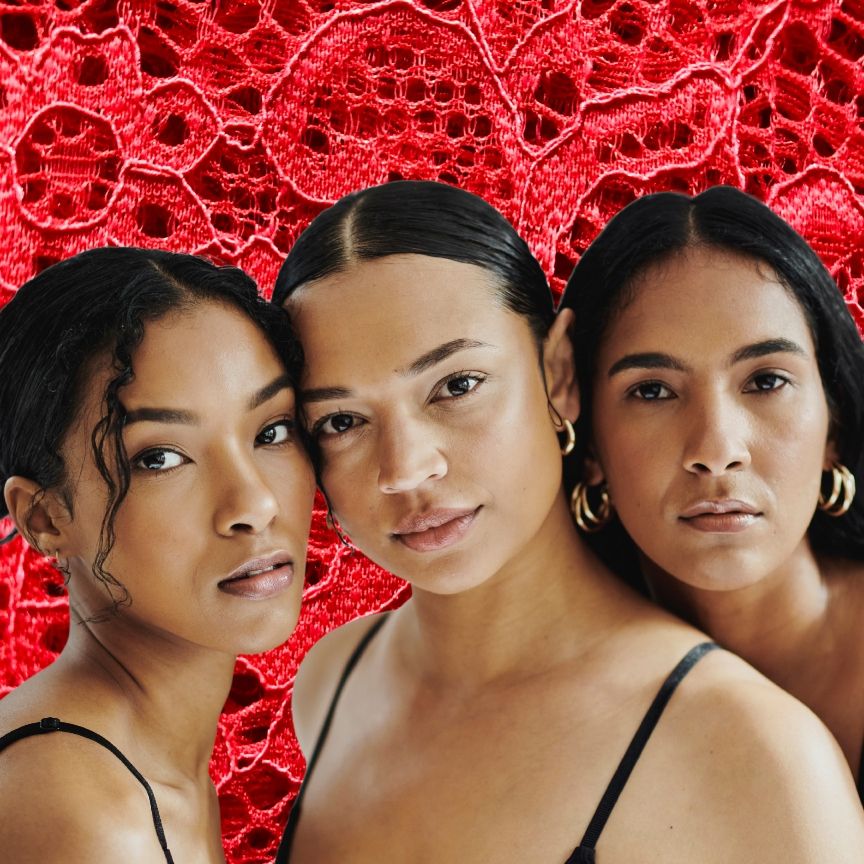 three women with soft glowing skin on a red lace background