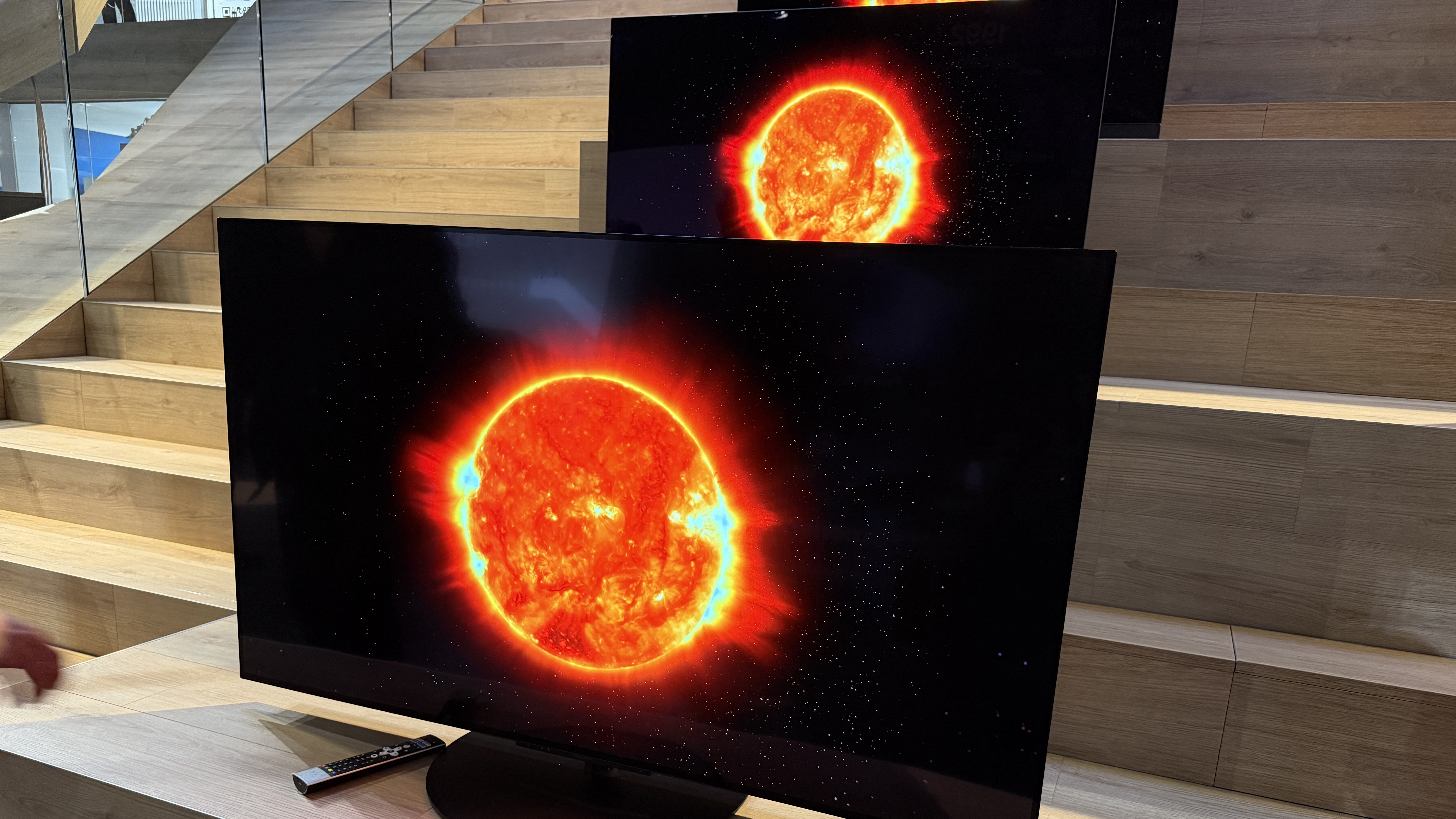 The Panasonic Z86C showing an image of the sun, with sun spots and corona flashes. The Panasonic Z90B TV is behind it, showing the same image