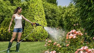 woman watering plants with Worx pressure washer