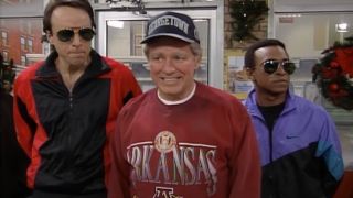 Phil Hartman's President Clinton smiles while flanked by Kevin Nealon and Tim Meadows on SNL.
