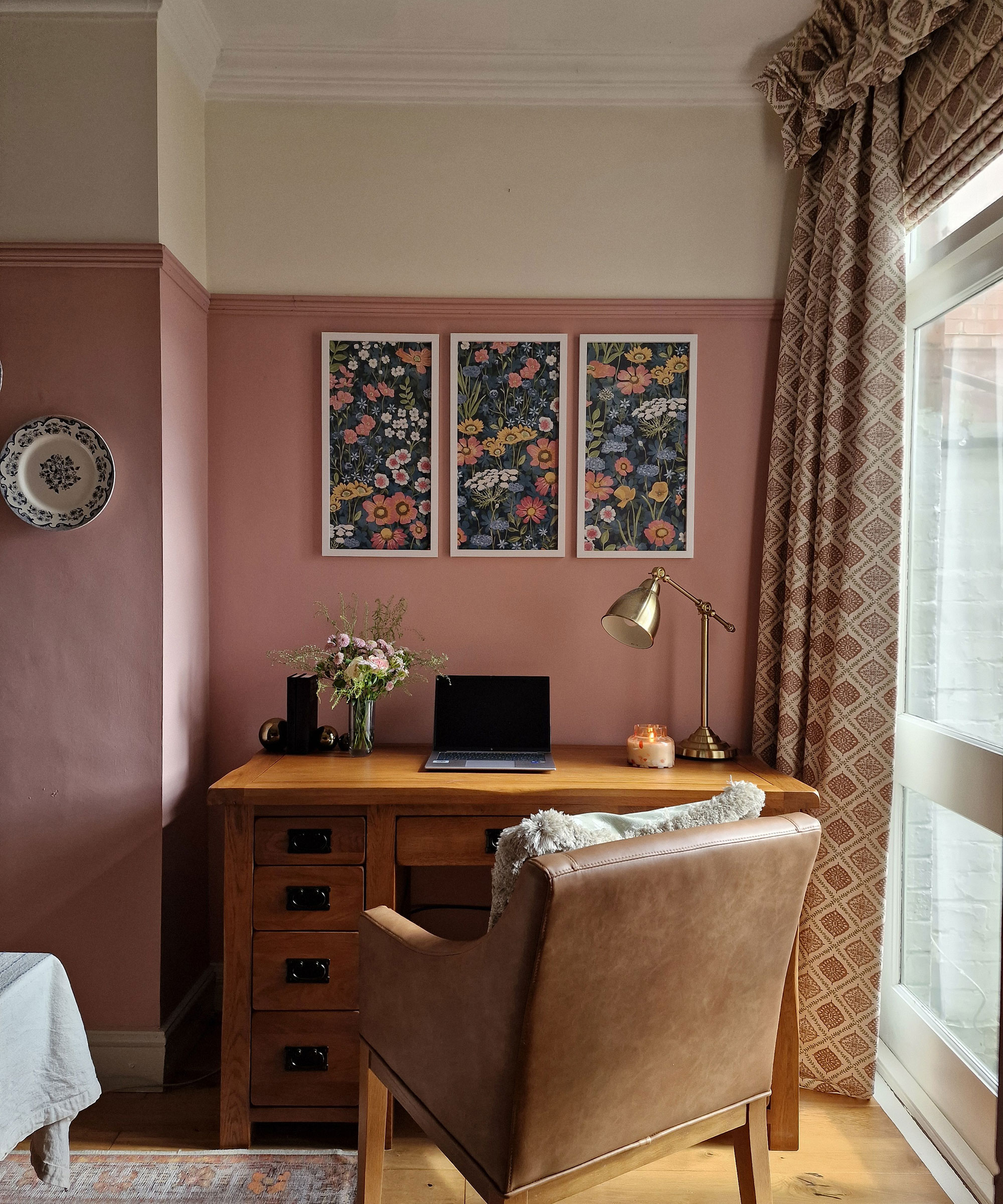 pink home office with chunky wooden design and leather desk chair with full length curtains