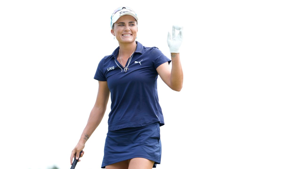 Lexi Thompson smiles and acknowledges fans at an LPGA event