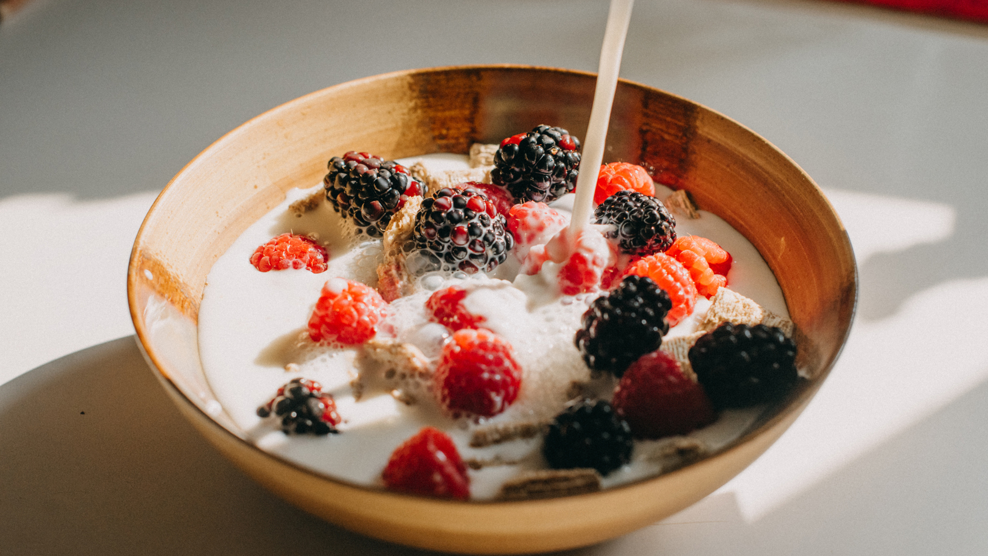 Oat milk poured over cereals and berries