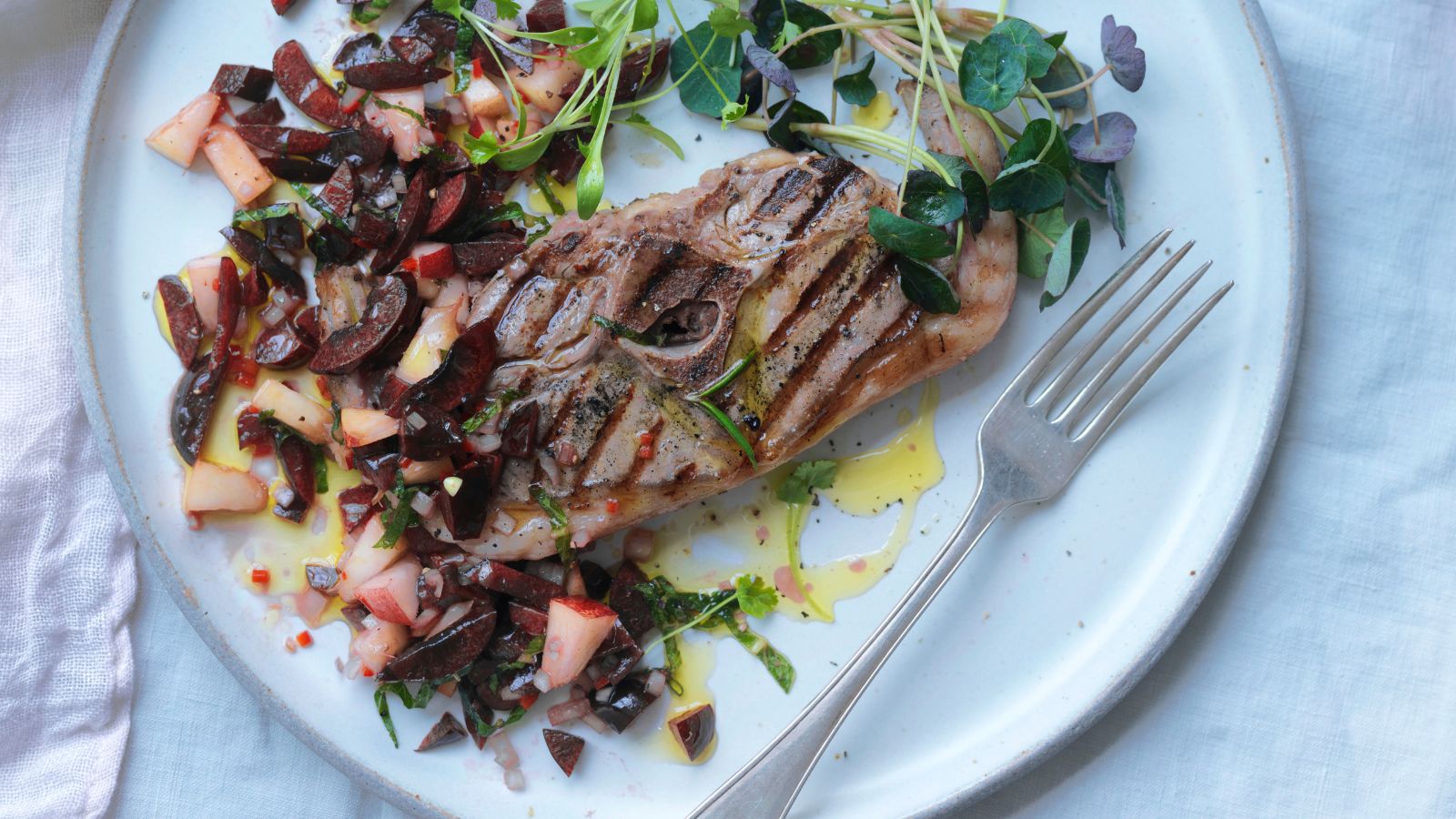 Plate of food with a piece of grilled fish and cherry and peach salsa