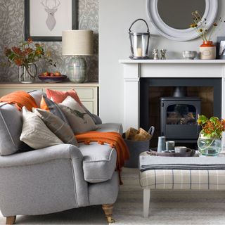 Living room with grey sofa and cushions and fireplace