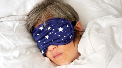 Mature woman sleeping in bed with eye mask close up