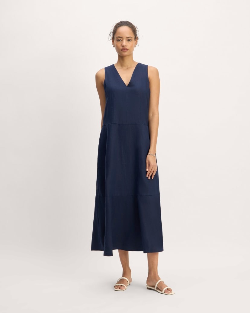 a model wears a midi-length blue shift dress with a V-neck