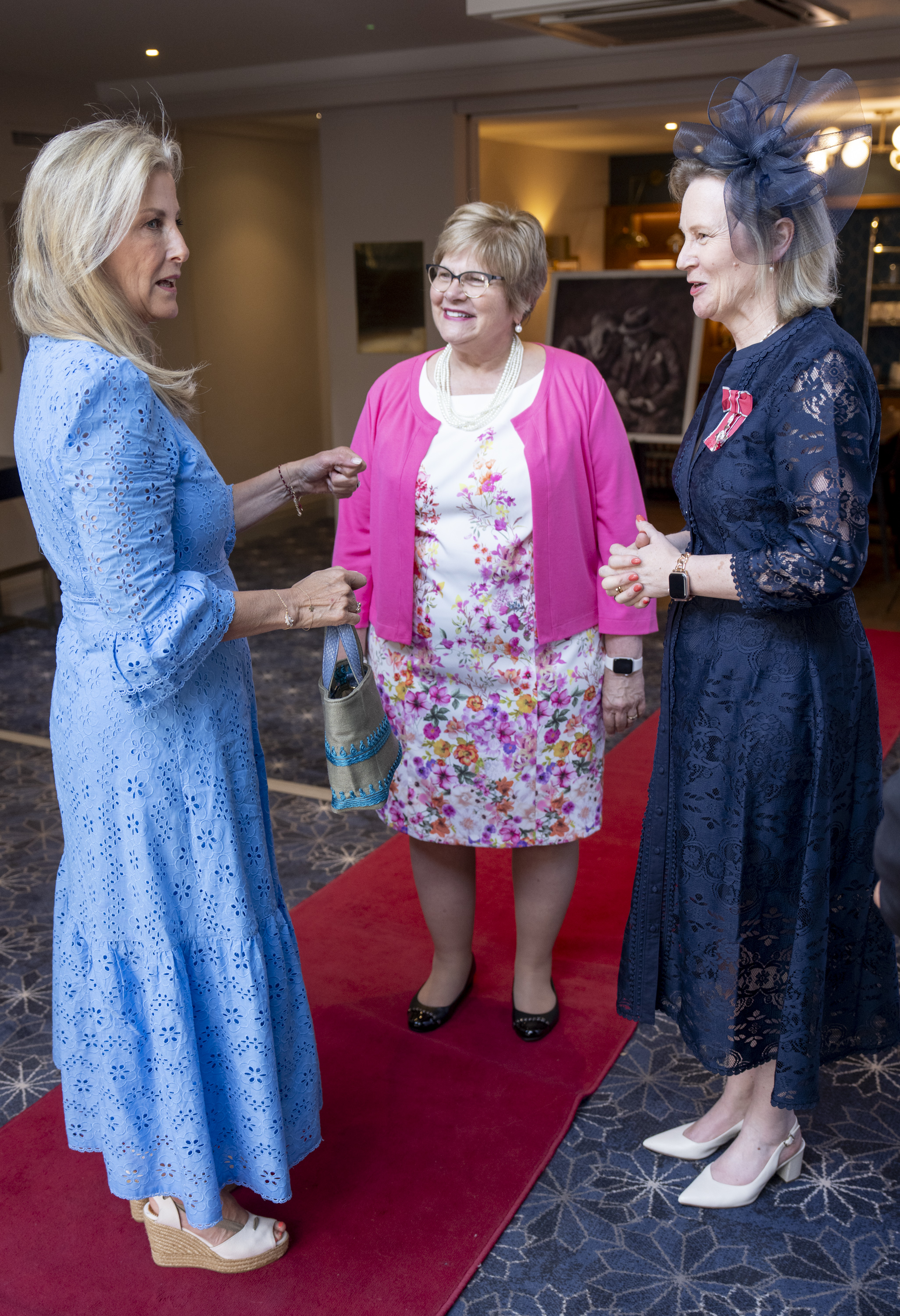 Duchess Sophie wearing a blue dress talking to two women