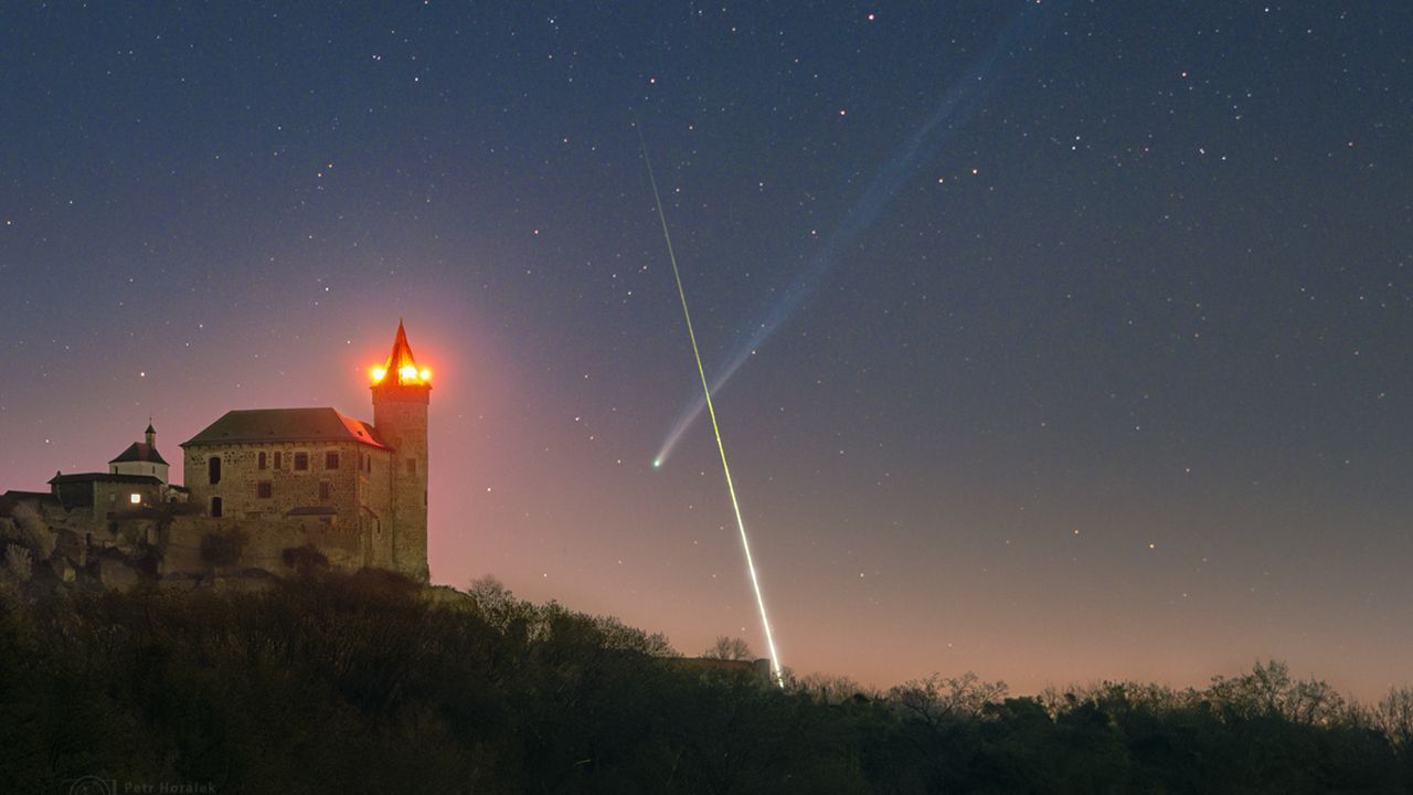 'What are the odds': Superbright comet and exploding fireball meteor form near-perfect X over European castle