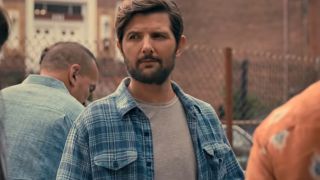 Adam Scott stands at a barbeque with a look of curiosity in Madame Web.