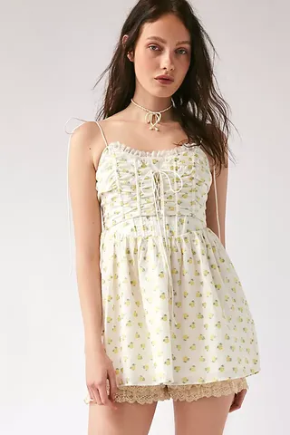 a model wears a white short floral sleeveless dress