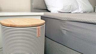 A close up of the Orion Sleep System Control Tower next to the Orion mattress cover on a bed in our reviewer's room