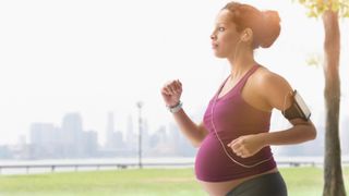 A pregnant woman running outdoors