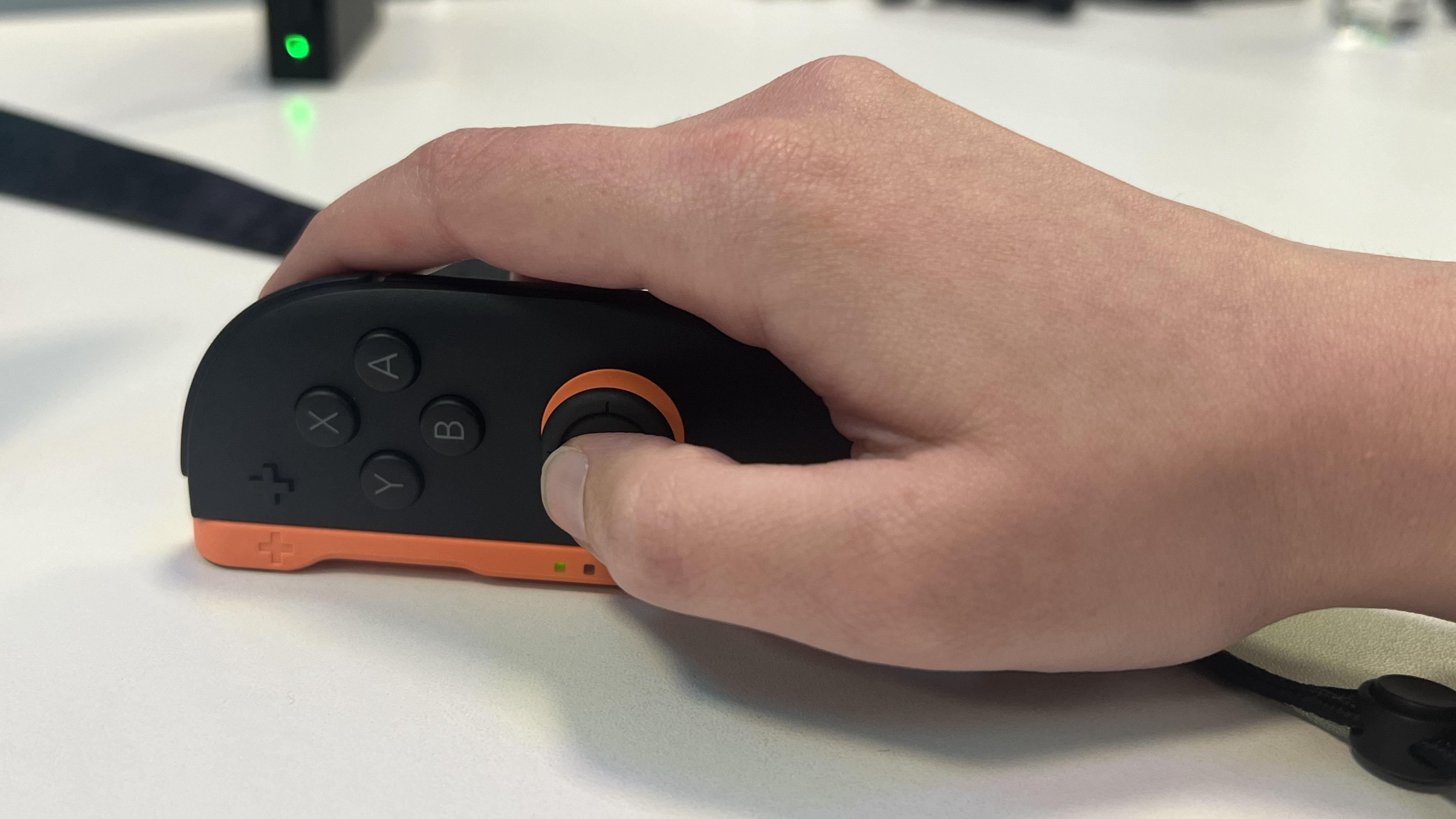 Hand using the Nintendo Switch 2 Joy-Con controller in its mouse setting