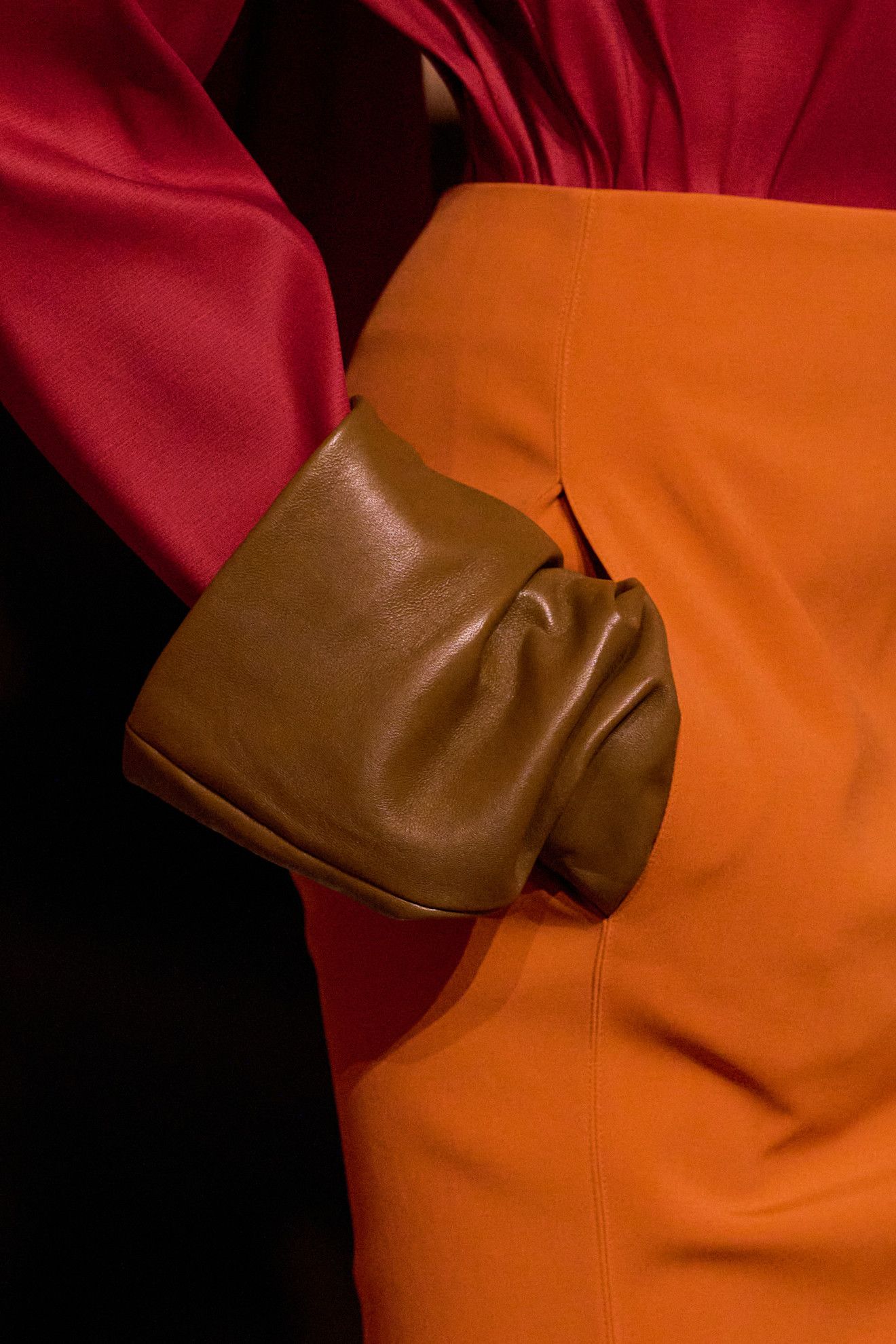 Model wearing colored gloves on the runway.
