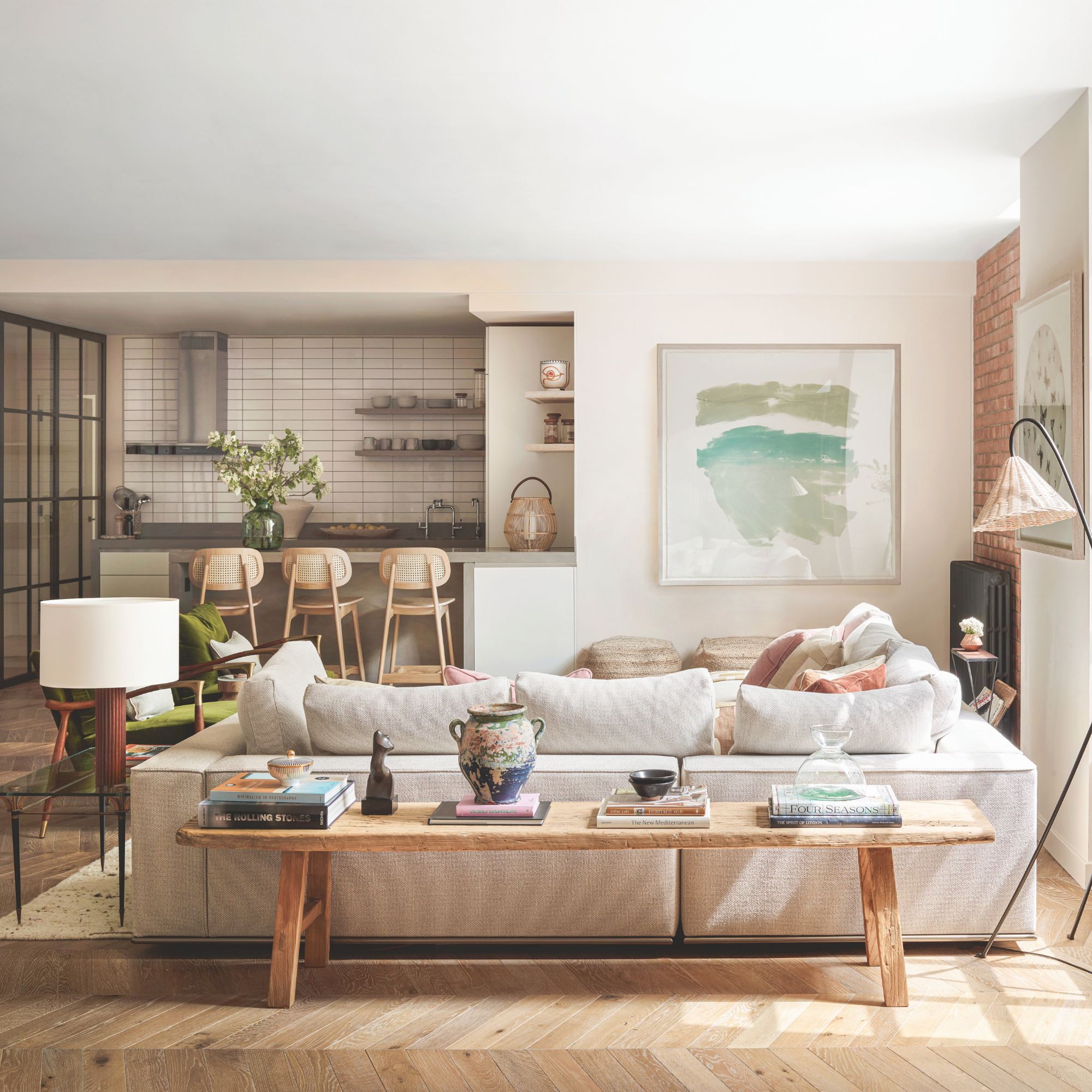 Open plan living room and kitchen with neutral woods, wooden flors and grey sofa