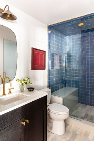 A modern bathroom with a blue tiled shower